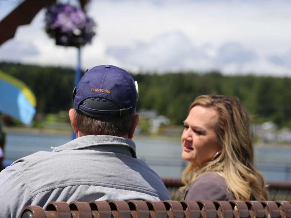 Tarra with a union member talking on a bench by the waterfront